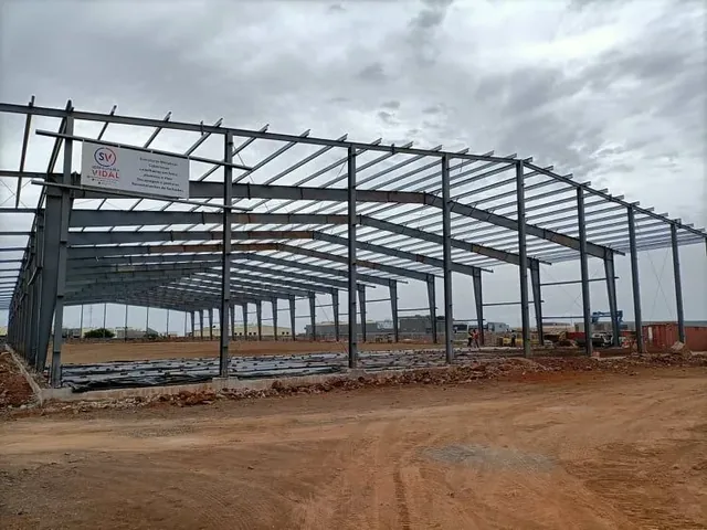 Estrutura metálica do pavilhão Khym Negoce com placa de obra da Serralharia Vidal